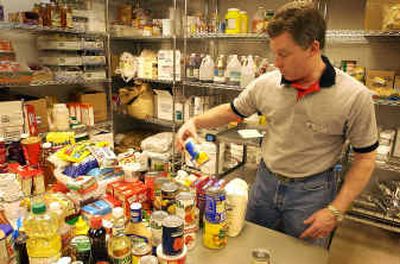 North Idaho College Food Service manager Randy Bennett sorts through donated food to prepare holiday boxes for families who might need help this Christmas.
(Jesse Tinsley / The Spokesman-Review)