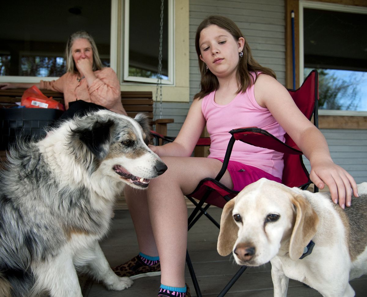 Aria Layton, sitting with her mother, Julia Hayes, did art therapy during her cancer treatment several years ago. She visits with her dogs Baloo, left, and Toby at her West Plains home. (Dan Pelle)