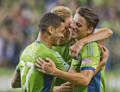 Sounders Lamar Neagle (left) and Marc Burch (right) hug after combining on Neagle’s goal. (Associated Press)