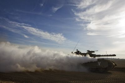 An Israeli tank drives near the border between Israel and the Gaza Strip on Thursday.  Israeli fighter jets were deployed for the first time in six months overnight, destroying unmanned targets in Gaza.  (Associated Press / The Spokesman-Review)