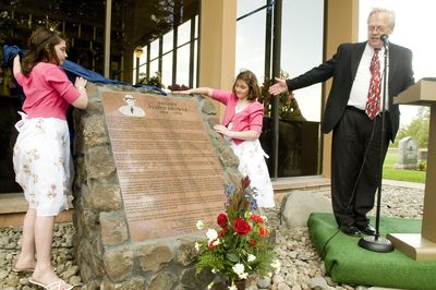 Twin great-granddaughters of Sheriff Floyd Brower, Emily and Katie Fruin, 10, and Duane Broyles, president of the Fairmount Memorial Association, unveil a monument in honor of Brower on May 14.  (Colin Mulvany / The Spokesman-Review)