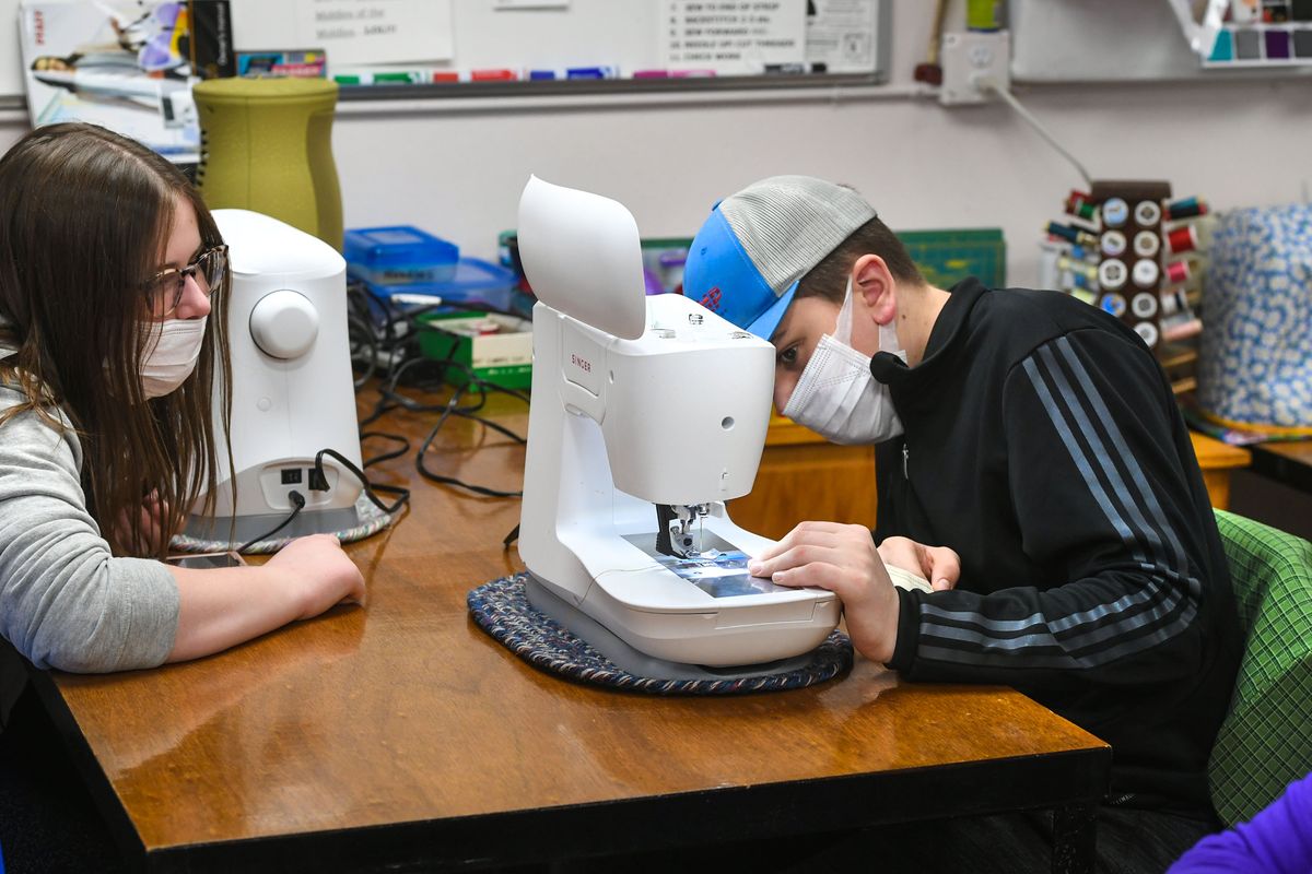 Emily, 12, left, and her brother, Elijah Meue, 12, set up their machines before proceeding with their holiday sew project, Thursday, Nov. 19, 2020, at Let’s Get Sewing school in Spokane.  (Dan Pelle/THESPOKESMAN-REVIEW)