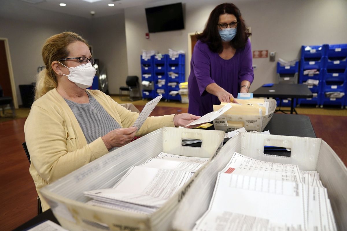 Board worker Ann Carlette, left, processes and double-checks mail-in ballots for Bergen County in Hackensack, N.J., Wednesday, Nov. 3, 2021. The first major election day following a year of relentless attacks on voting rights and election officials went off largely without a hitch. The relative calm was a relief to those who oversee state and local elections, but election experts say that might not matter to the millions of Americans who now believe in conspiracy theories trumpeting rampant electoral fraud.  (Seth Wenig)