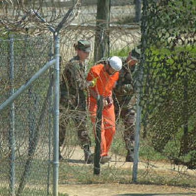 
A detainee is taken to an interrogation session by U.S. military guards at Camp X-Ray at the U.S. naval base at Guantanamo Bay, Cuba, in this  Feb. 27, 2002, file photo. 
 (Associated Press / The Spokesman-Review)