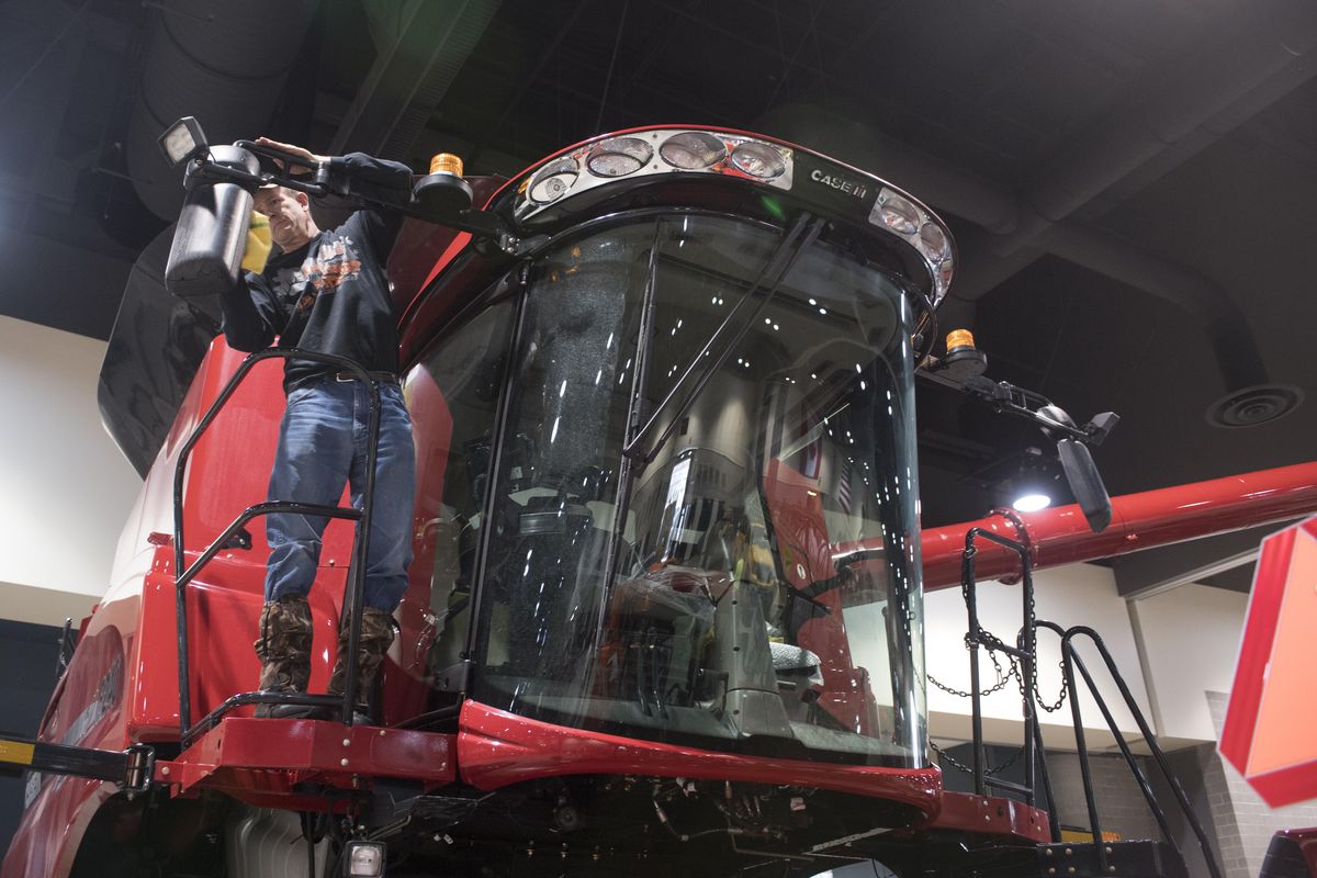 Chris Flesher wipes down a Case combine Sunday, Feb. 5, 2017, in preparation for this week’s Ag Trade Show at the Spokane Convention Center. Flesher is a territory sales manager for Case IH Agriculture. (Jesse Tinsley / The Spokesman-Review)
