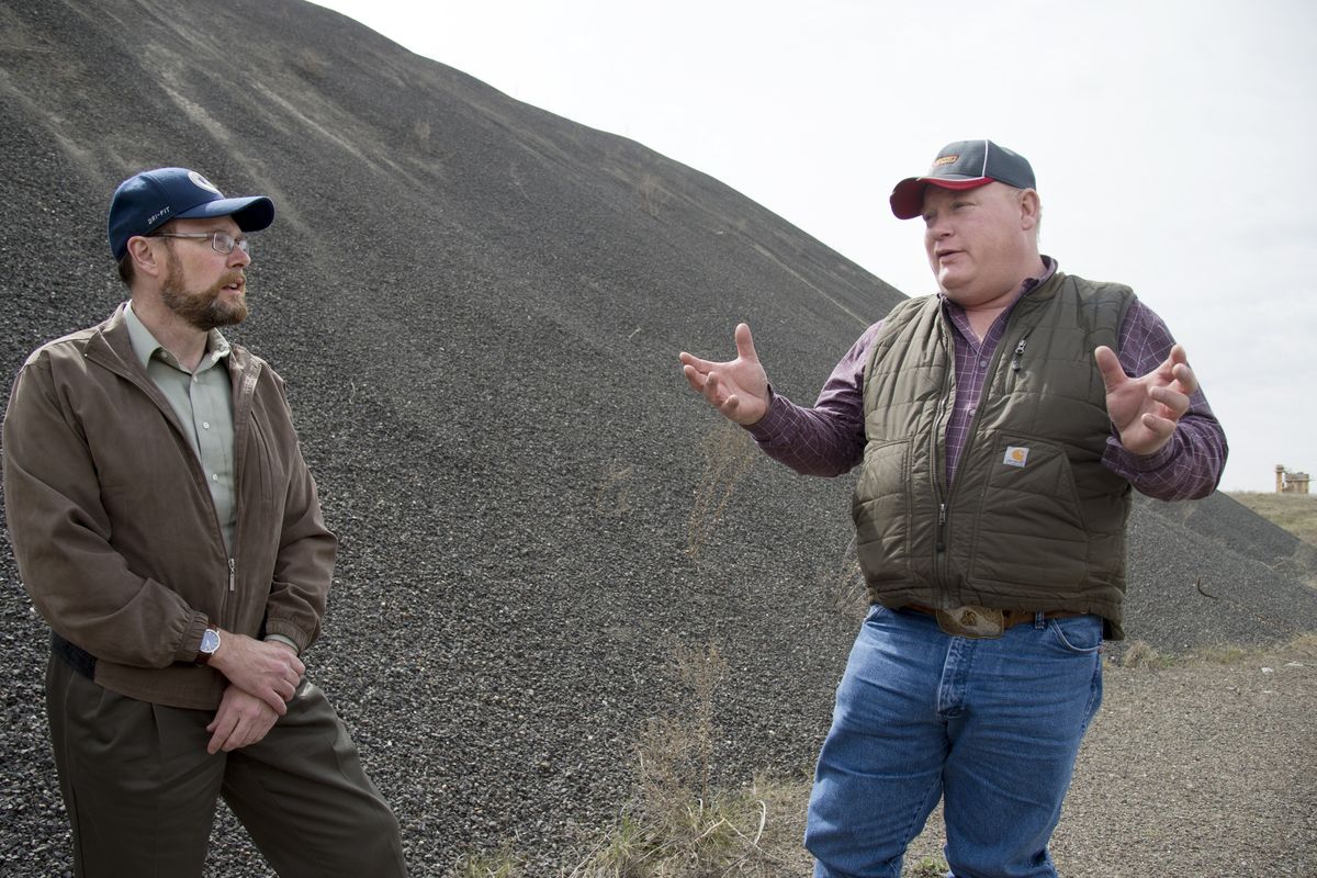 Chad Coles, left, and Jim Cotter of Spokane County talk about the importance of gravel pits April 13 at a stockpile of crushed gravel at a pit on Hayford Road. (Jesse Tinsley)