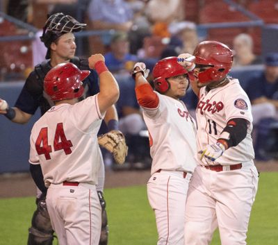 Isaias Quiroz, right, celebrates with Tanner Gardner, left, and Francisco Ventura, center, after he brought them in with a three-run home run against the Everett AquaSox at Avista Stadium on Sept. 6. The Indians Player Development Agreement with the Texas Rangers was renewed by the parent club on Monday. (Jesse Tinsley / The Spokesman-Review)