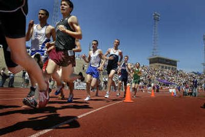 
Andrew Kimple of North Central (in red shorts) rounds the first turn of the second lap of the 1600 meter finals at the  State  3A meet in Pasco Saturday. 
 (CHRISTOPHER ANDERSON / The Spokesman-Review)