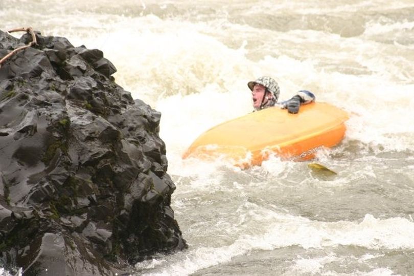 Blake Sommers goes for a swim as he tests his new kayak in the Spokane River on Jan. 26, 2012. (Brian Jamieson)
