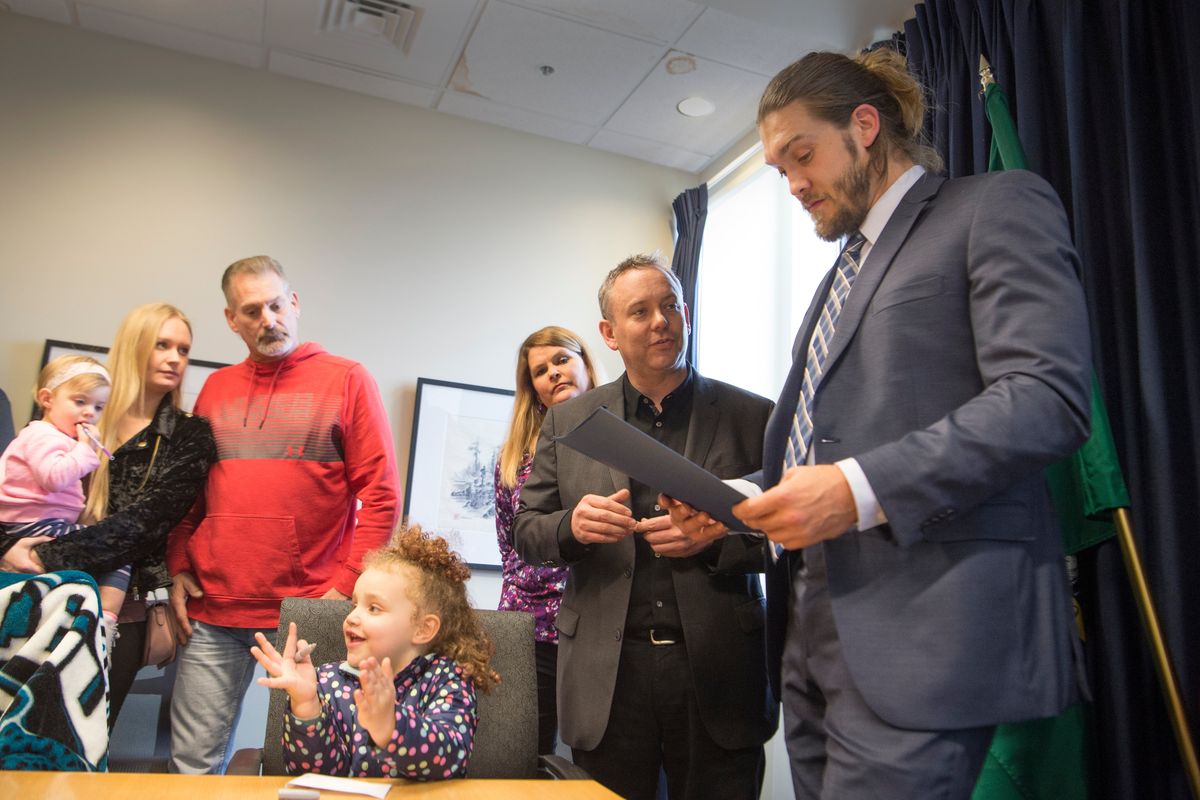 Philadelphia Eagles special teams player Bryan Braman, right, surrounded by family members, receives a proclamation and a commemorative coin on March 16, 2018 from Spokane Mayor David Condon, second from right, at Spokane City Hall. (JESSE TINSLEY/The Spokesman-Review)