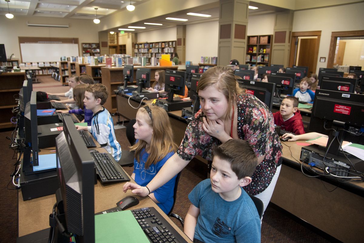 Finch Elementary School fourth-grade teacher Kalandra Zenger works with her students on math skills in the computer lab inside the north Spokane school’s new library on Monday, the day the historic building reopened.