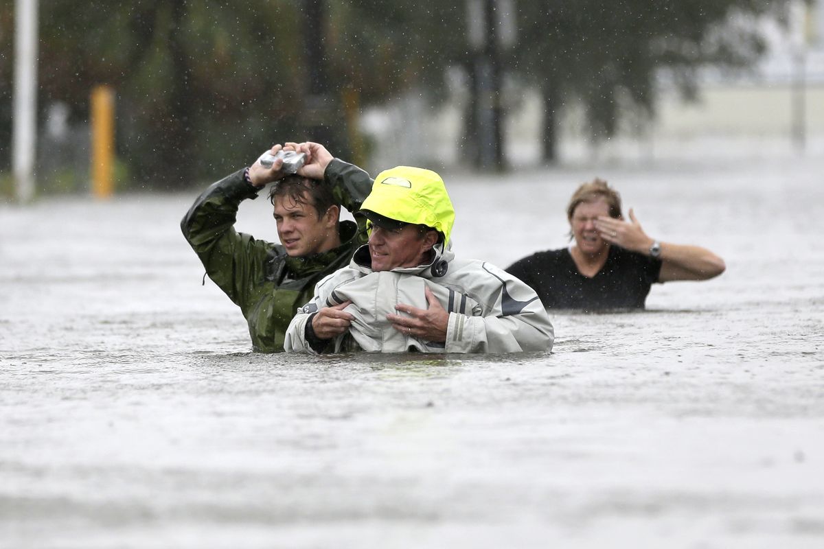 Chuck Cropp, center, his son Piers, left, and wife, Liz, wade through floodwaters from Hurricane Isaac in New Orleans on Wednesday. (Associated Press)