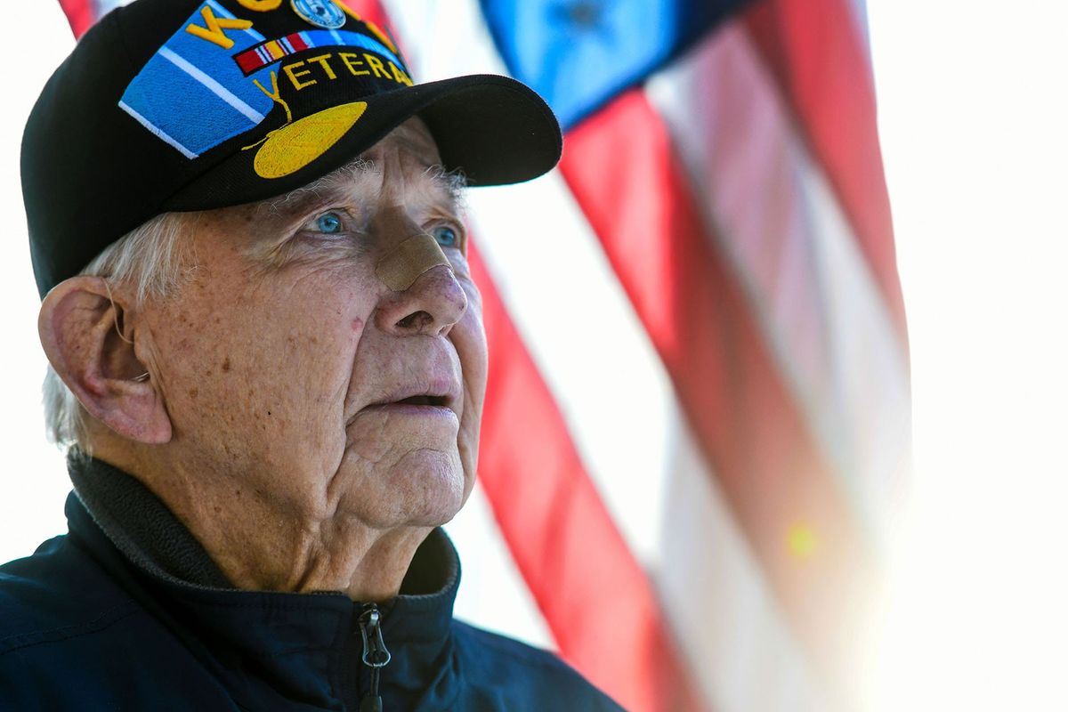 Veteran Hal Donahue stands Wednesday near the flag at his home in Hayden.  (Kathy Plonka/The Spokesman-Review)
