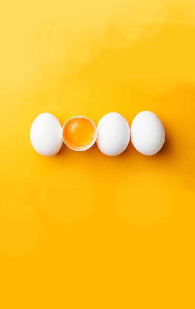 White eggs and egg yolk on the yellow background.  (Shutterstock)