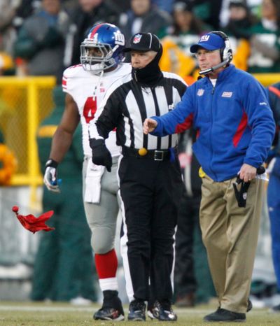 Giants coach Tom Coughlin throws the challenge flag during last week’s game. (Associated Press)