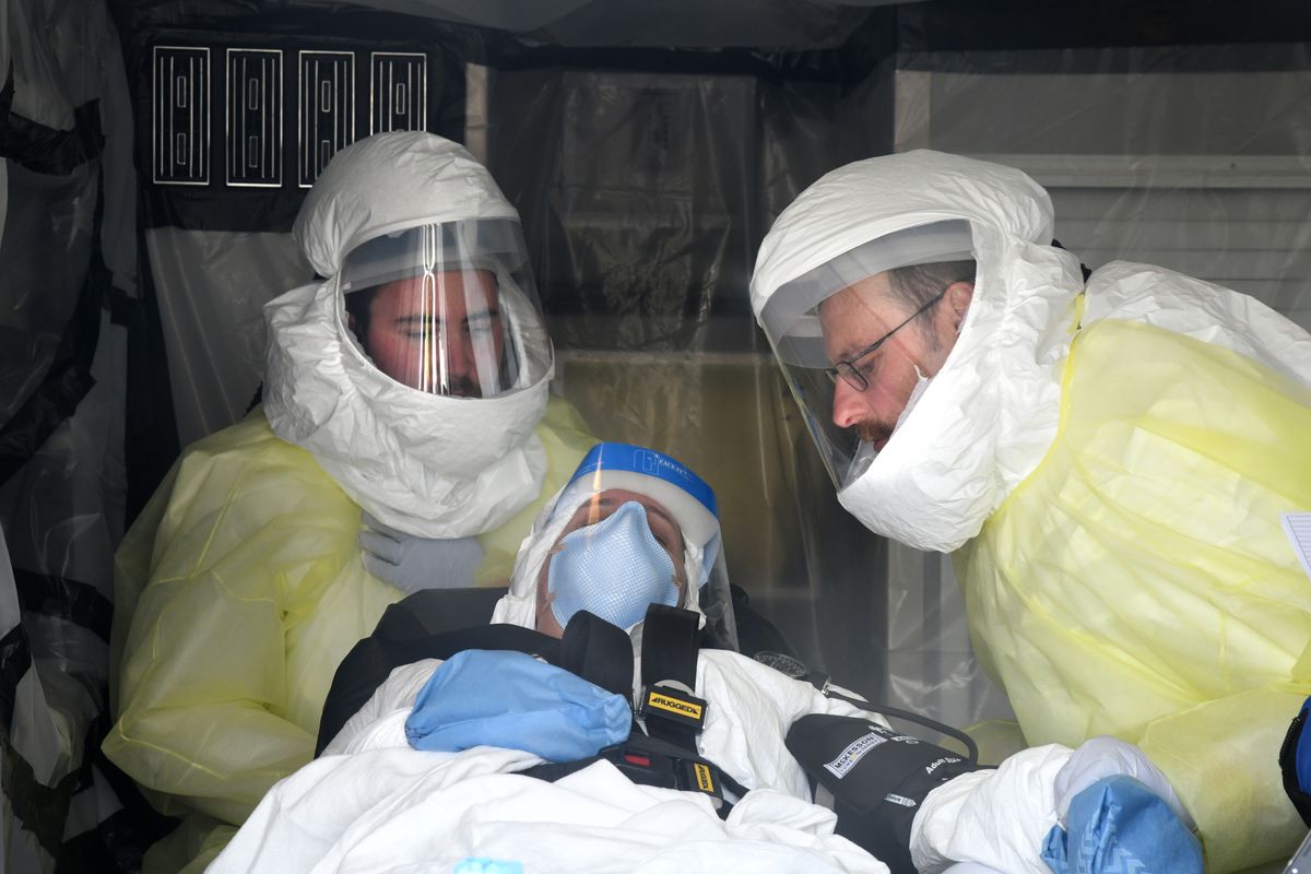 Mock Ebola patient Barbara Cooper is loaded into an ambulance during the Tranquil Terminus exercise, April 11, 2018, at Spokane International Airport. An infusion of federal money for disaster preparedness followed an outbreak of Ebola in Africa.  (DAN PELLE/THE SPOKESMAN-REVIEW)