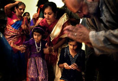 
At the end of a Hindu ceremony, people give offerings to Ganesha and Krishna. About 60 people gathered for the celebration at the Nandagopal family's north Spokane home Friday night. 
 (Jed Conklin / The Spokesman-Review)