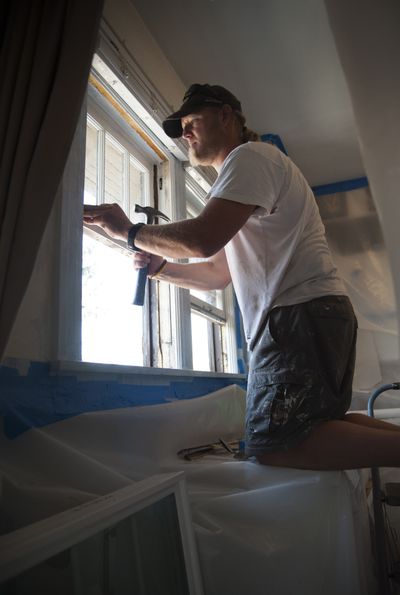After sealing the kitchen with plastic sheeting, contractor Ben Bersagel removes old windows contaminated with lead from a north Spokane home. Minimizing the spread of lead is a key part of various local programs for low- and moderate-income families. See page C3. (Colin Mulvany)