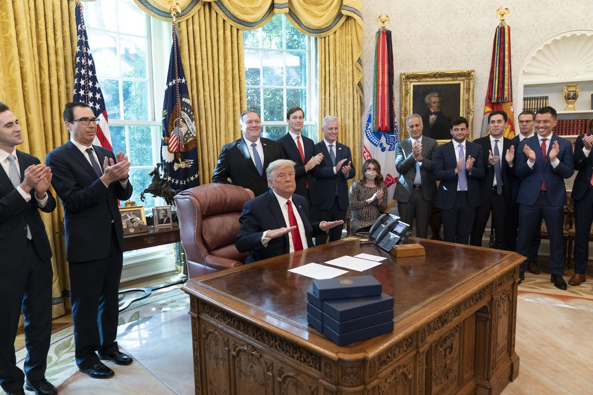 President Donald Trump reacts after hanging up a phone call with the leaders of Sudan and Israel, as Treasury Secretary Steven Mnuchin, second from left, Secretary of State Mike Pompeo, White House senior adviser Jared Kushner, National Security Adviser Robert O