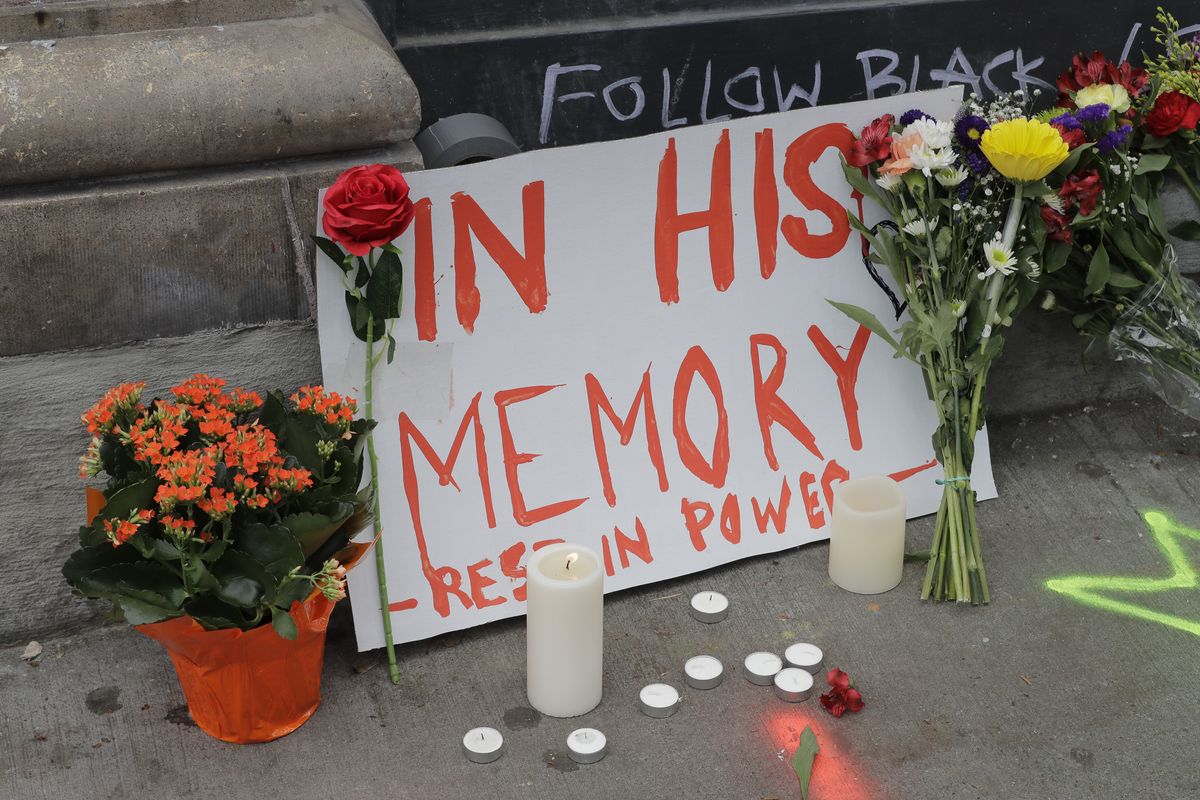 A sign that reads “In his Memory Rest in Power,” is displayed at a growing memorial to a person named Lorenzo on Saturday, at the intersection of 10th Avenue and Pine Street near the Capitol Hill Occupied Protest zone in Seattle. A pre-dawn shooting near the area left one person dead and critically injured another person, authorities said Saturday. (Associated Press)