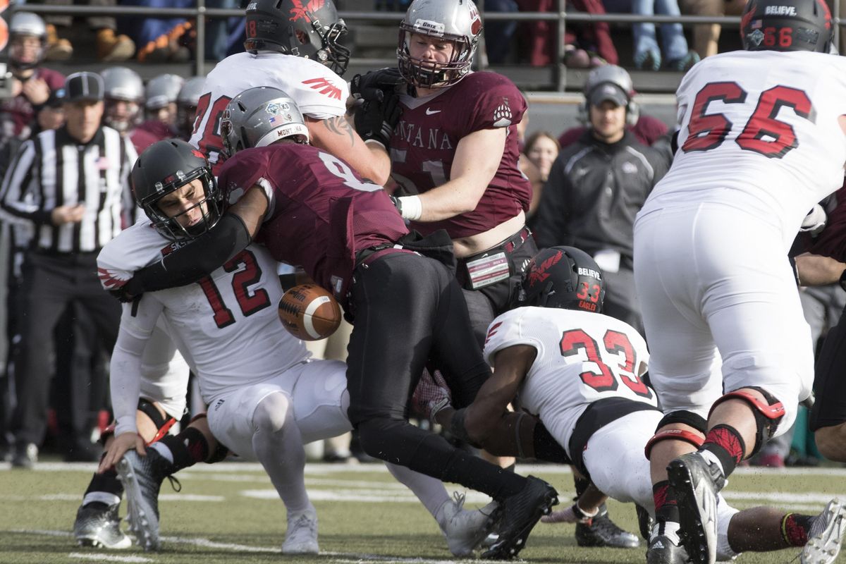 In last year’s matchup in Missoula, Eastern Washington quarterback Reilly Hennessey (12) fumbles as he is hit by safety Manu Rasmussen. EWU used three QBs in the game. (Patrick Record / Associated Press)