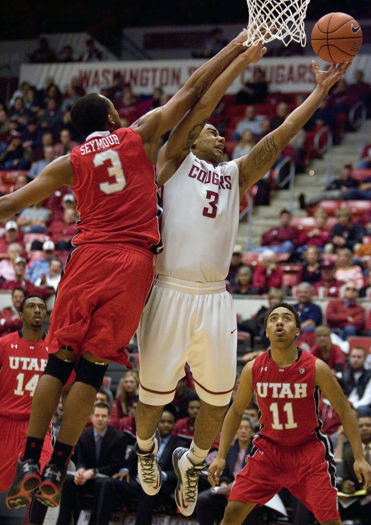 Utah’s Justin Seymour fouls Washington State’s DaVonte Lacy during the second half. (Associated Press)