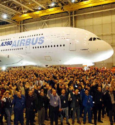 
Airbus employees wave next to the new Airbus A380 after its unveiling ceremony near Toulouse on Tuesday. 
 (Associated Press photos / The Spokesman-Review)
