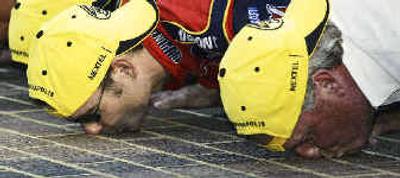 
Driver Jeff Gordon, left, and car owner Rick Hendrick kiss the yard of bricks at the Indianapolis Motor Speedway after Gordon won the Brickyard 400. 
 (Associated Press / The Spokesman-Review)