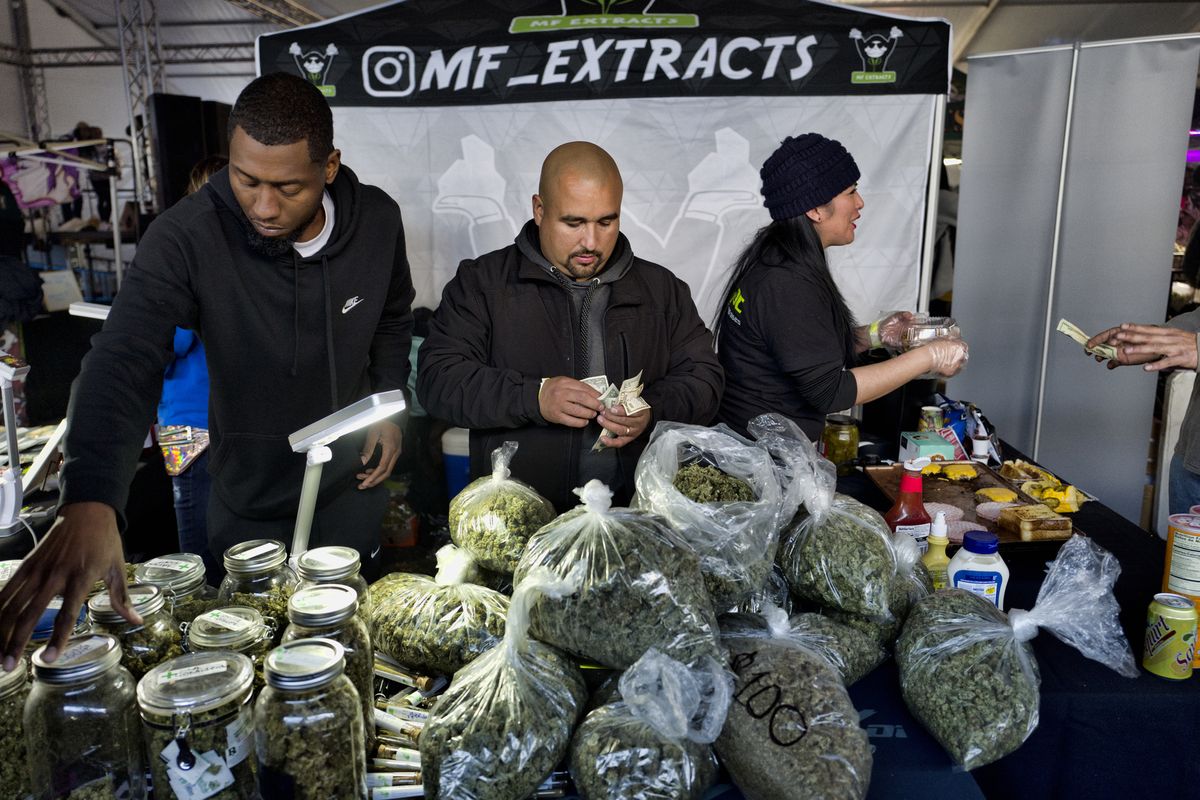 Vendors from MF Extracts count their intake of cash at their booth at Kushstock 6.5 festival in Adelanto Calif., on Saturday, Dec. 29, 2018.  (Associated Press)