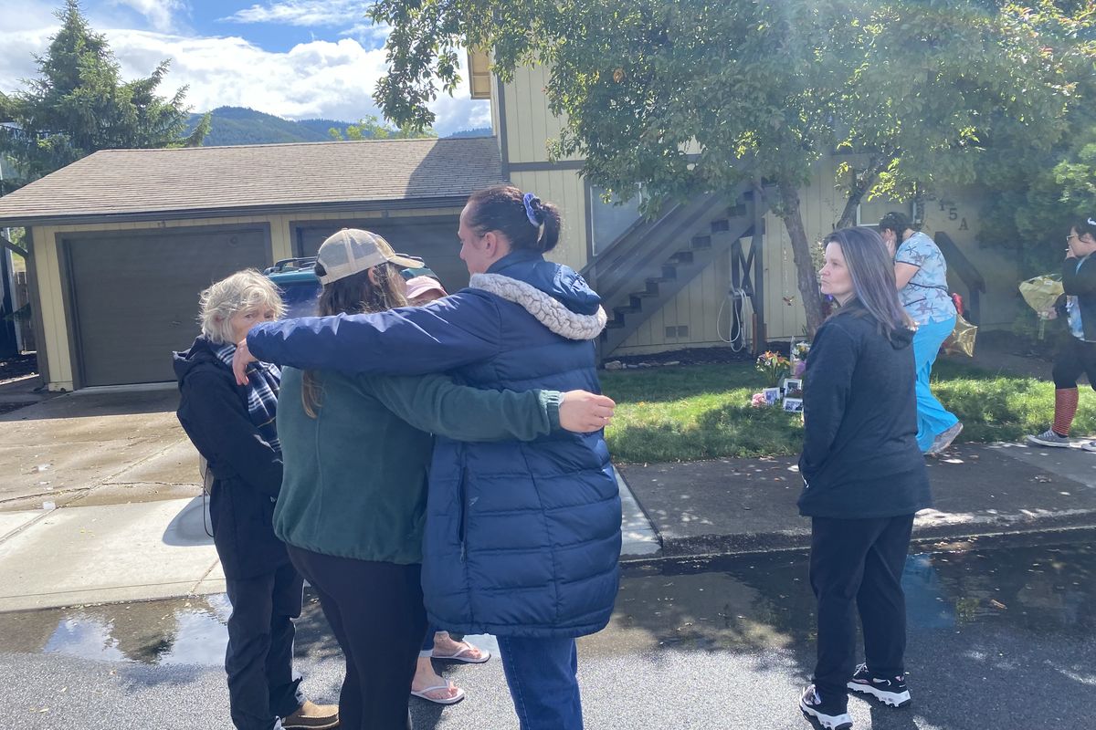Katy James, left, and Merissa Anderson, right, hug in front of the Kellogg home where their friends Kenna and Kenneth Guardipee, along with Devin and Aiken Smith, were killed Sunday evening.  (Emma Epperly / The Spokesman-Review)