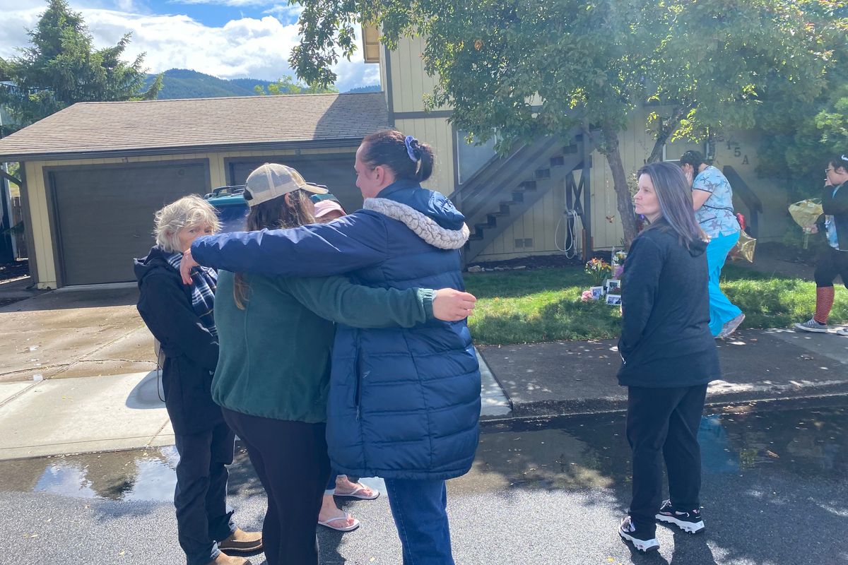 Katy James, left, and Merissa Anderson, right, hug in front of the Kellogg home where their friends Kenna and Kenneth Guardipee, along with Devin and Aiken Smith, were killed Sunday evening.  (Emma Epperly / The Spokesman-Review)