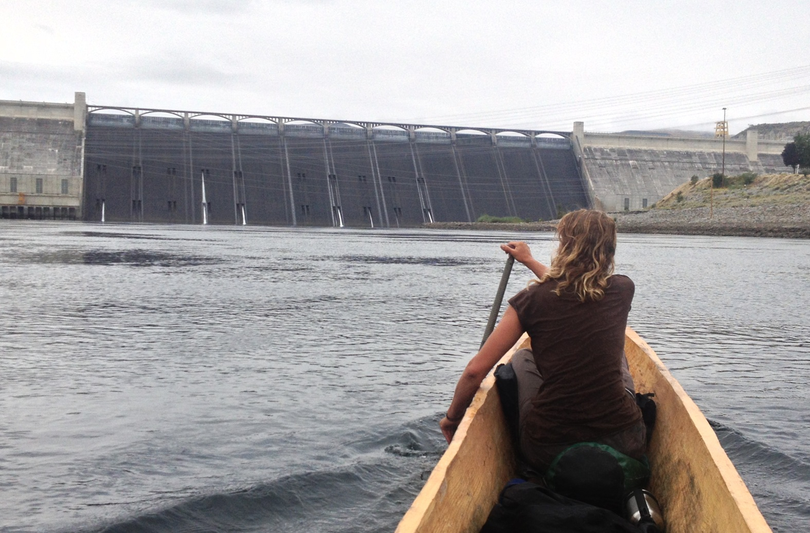 Donna-Gay Ward of Northport, Wash., paddles in the bow of a Sea 2 Source canoe approaching the downstream side of Grand Coulee Dam on Sept. 6, 2013 during a summer journey up the Columbia River to spotlight the plight of salmon runs that must pass dams en route to spawning grounds. The group is rallying support to pressure federal hydropower managers to install a fish ladder at Grand Coulee Dam. (Adam Wicks-Arshack  / Voyages of Rediscovery)