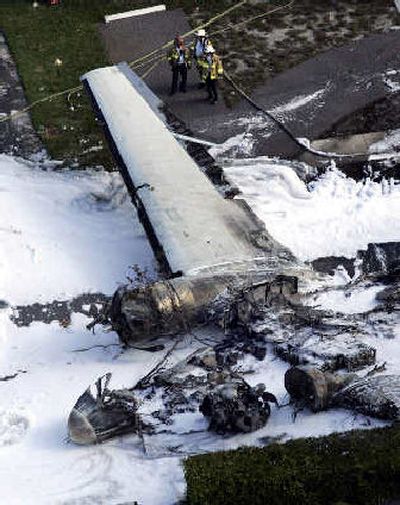 
Firefighters look over the wreckage of a World War II-era DC-3 cargo plane that crashed and burned after takeoff on Monday near Fort Lauderdale Executive Airport, Fla. The three men aboard the plane and two on the ground were hurt. 
 (Associated Press / The Spokesman-Review)