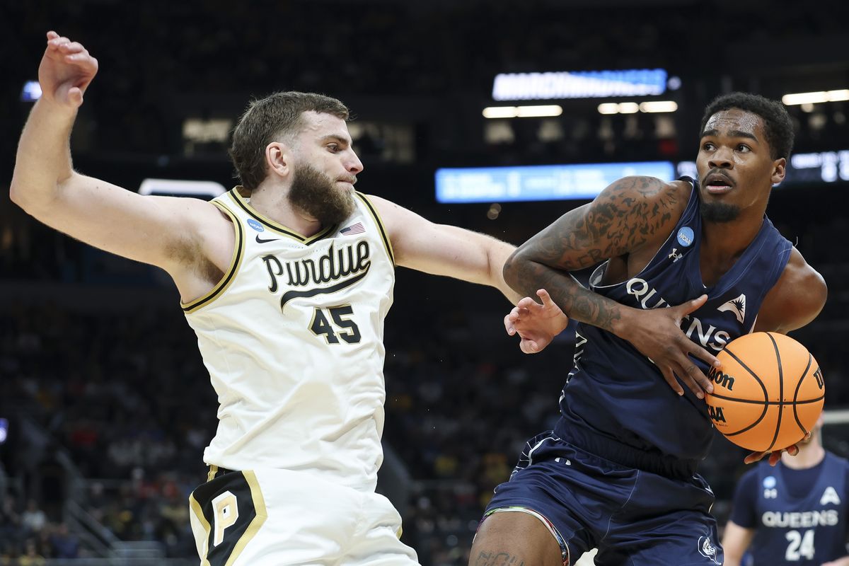 Queens forward Avantae Parker, right, drives to the basket against Purdue defender Oscar Cluff during the first round of the NCAA Tournament at Enterprise Center on Friday in St Louis, Missouri.  (Getty Images)