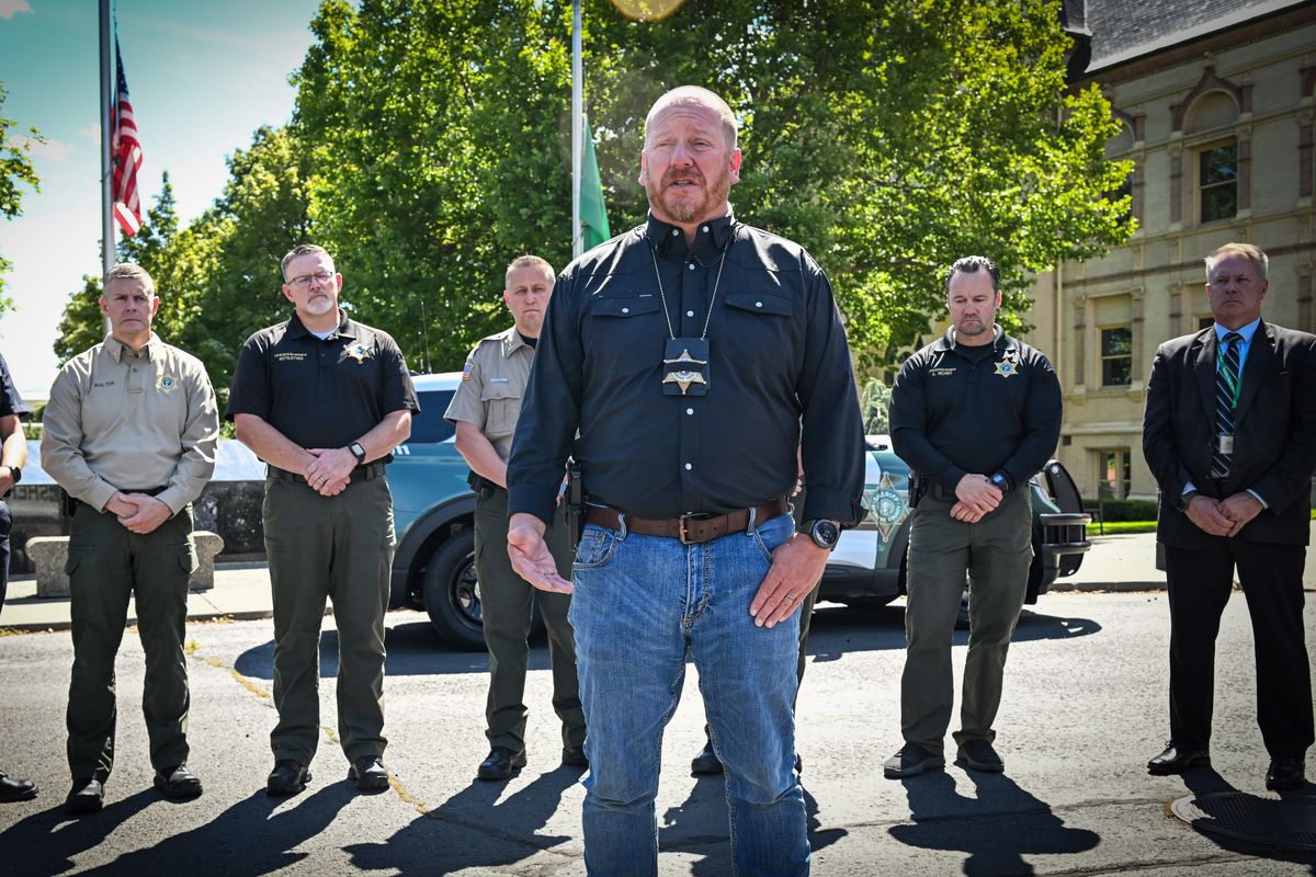 Spokane County Sheriff John Nowels, center right, stands outside the Public Safety Building on Saturday and talks about the death of Sergeant Kenneth Salas, who was killed on I-90 east of Spokane Saturday morning. Salas, who had 30 years of service with the county and was planning to retire next month, was struck by a motorcycle after stopping to try and remove a hay bale off of the interstate. (Jesse Tinsley/The Spokesman-Review)