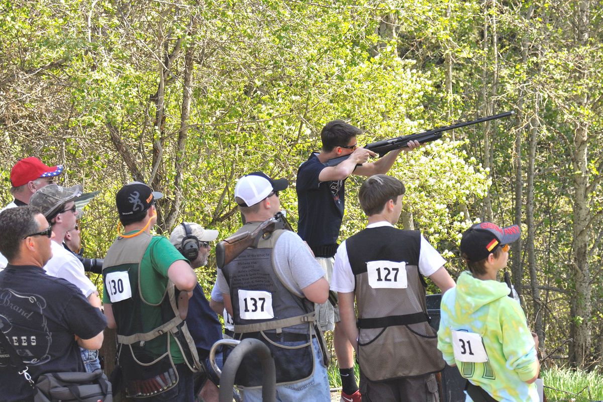 A shooter surrounded by teammates fires in the sporting clays event during the Washington Youth Education in Shooting Sports state meet. (Rich Landers)