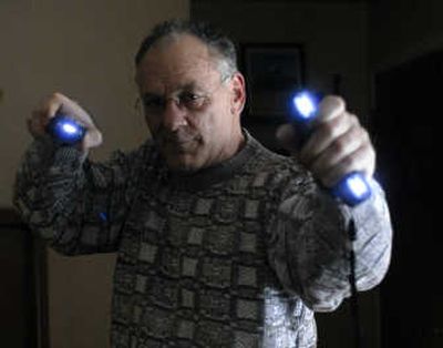 
Mark Hughes demonstrates the Blast Knuckle stun gun and the Double Trouble stun gun.  
 (J. BART RAYNIAK / The Spokesman-Review)