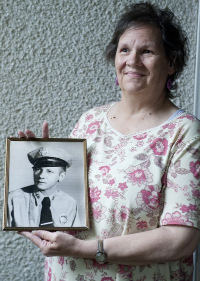 Carol Materne poses for a photo with a portrait of her husband  Frank 