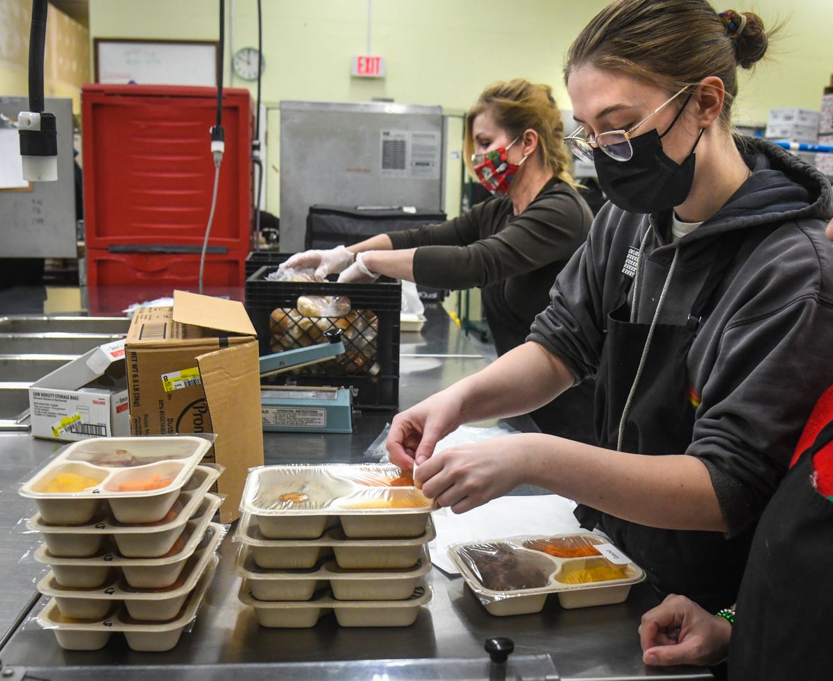 Josie Phillips, right, and her mother, Lola Phillips, of Greater Spokane County Meals on Wheels, attach labels to meals, Thursday morning, Dec. 24, 2020, that were delivered to to some 538 clients in by the afternoon.  (DAN PELLE/THE SPOKESMAN-REVIEW)