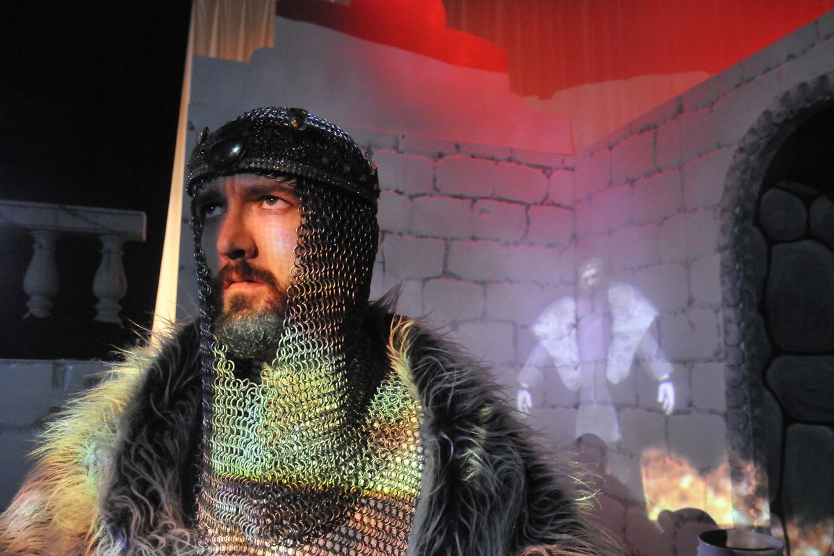Actor Geoffrey Lang, who plays Hamlet’s father in an upcoming production of “Hamlet” at Spokane Falls Community College, stands in front of the set Friday. Behind him, projected on the set, is an electronic version of his character. (Jesse Tinsley)