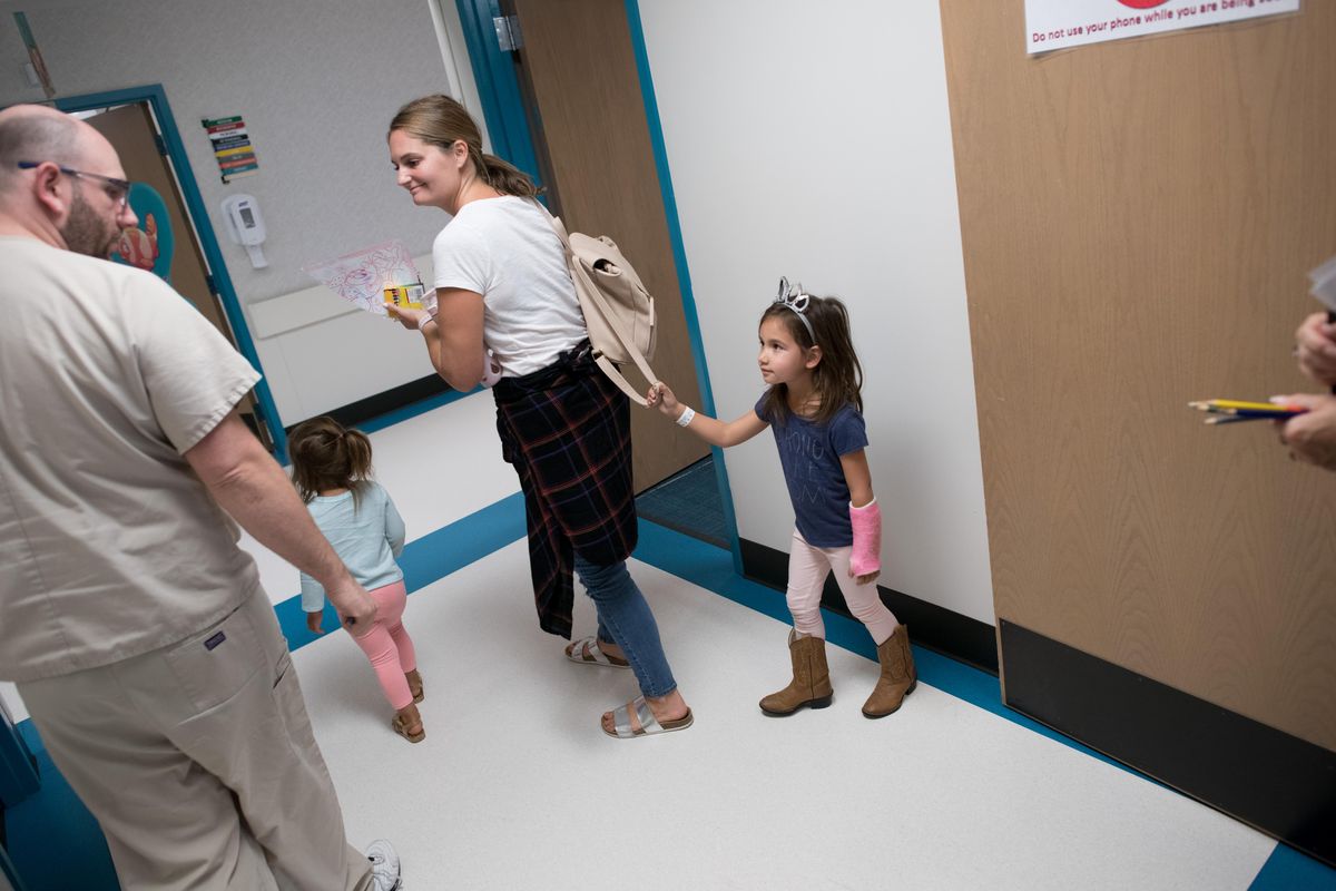 Mabel Martin, 4, hangs onto her mother Kelsey’s purse as they follow cast tech Scott Martin into the cast room on Tuesday, Aug. 21, 2018, at Shriners Hospitals for Children in Spokane, Wash. (Tyler Tjomsland / The Spokesman-Review)