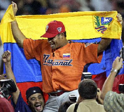 
Venezuelan Bobby Abreu holds his nation's flag after winning the Home Run Derby. 
 (Associated Press / The Spokesman-Review)