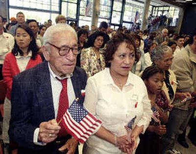 
Francisco Sarauia, left, stands with family members during a naturalization ceremony on July 4, 2003, in Seattle. A judge has certified a lawsuit against the Seattle immigration office as a class-action case. 
 (File/Associated Press / The Spokesman-Review)