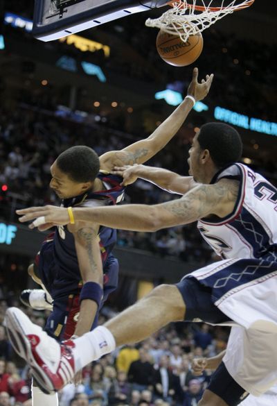 Cleveland’s Jamario Moon, left, is fouled by the Nets’ Devin Harris  (Associated Press)