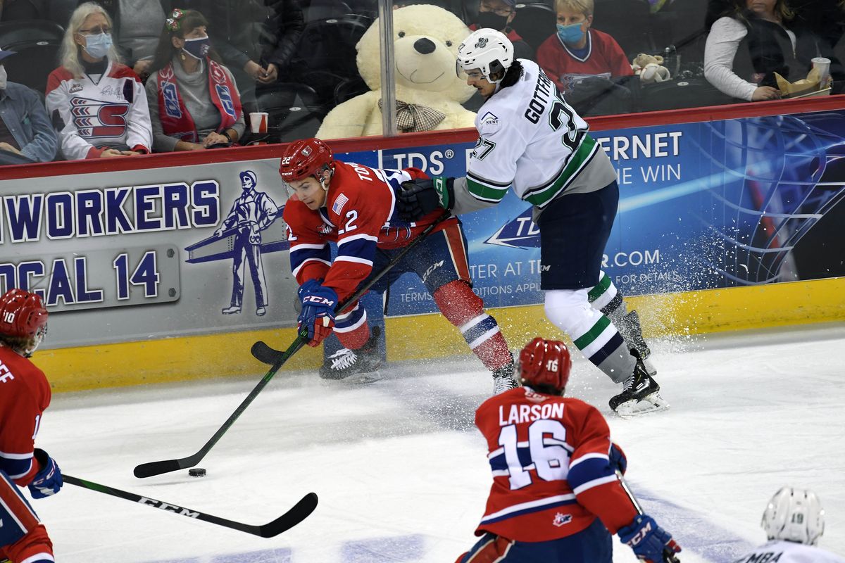 Spokane Chiefs forward Luke Toporowski (22) and Seattle Thunderbirds forward Ryan Gottfried (27) compete for control of the puck during the first period of a WHL hockey match, Saturday, Dec. 4, 2021, in the Spokane Arena.  (COLIN MULVANY/THE SPOKESMAN-REVIEW)