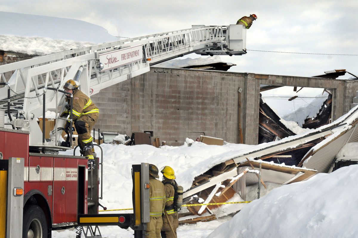 Spokane firefighters use an aerial ladder to check a warehouse at 2801 N. Pittsburgh after the roof collapsed Friday, Jan. 2, 2009.  A thermal imaging camera was used when one employee was unaccounted for and to check for possible fires.  Officials reported the structure belonged to Interior Solutions. (Christopher Anderson / The Spokesman-Review)