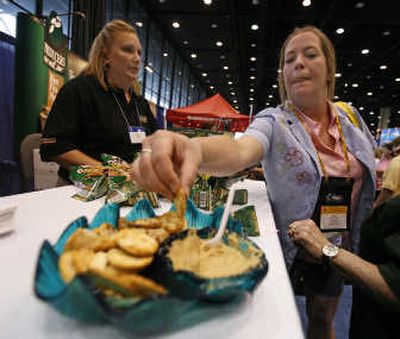 
Robin Lightfoot, left, of Garden City, Kan., listens to Kathy Cheop as she samples hummus at the School Nutrition Association annual meeting. Associated Press photos
 (Associated Press photos / The Spokesman-Review)