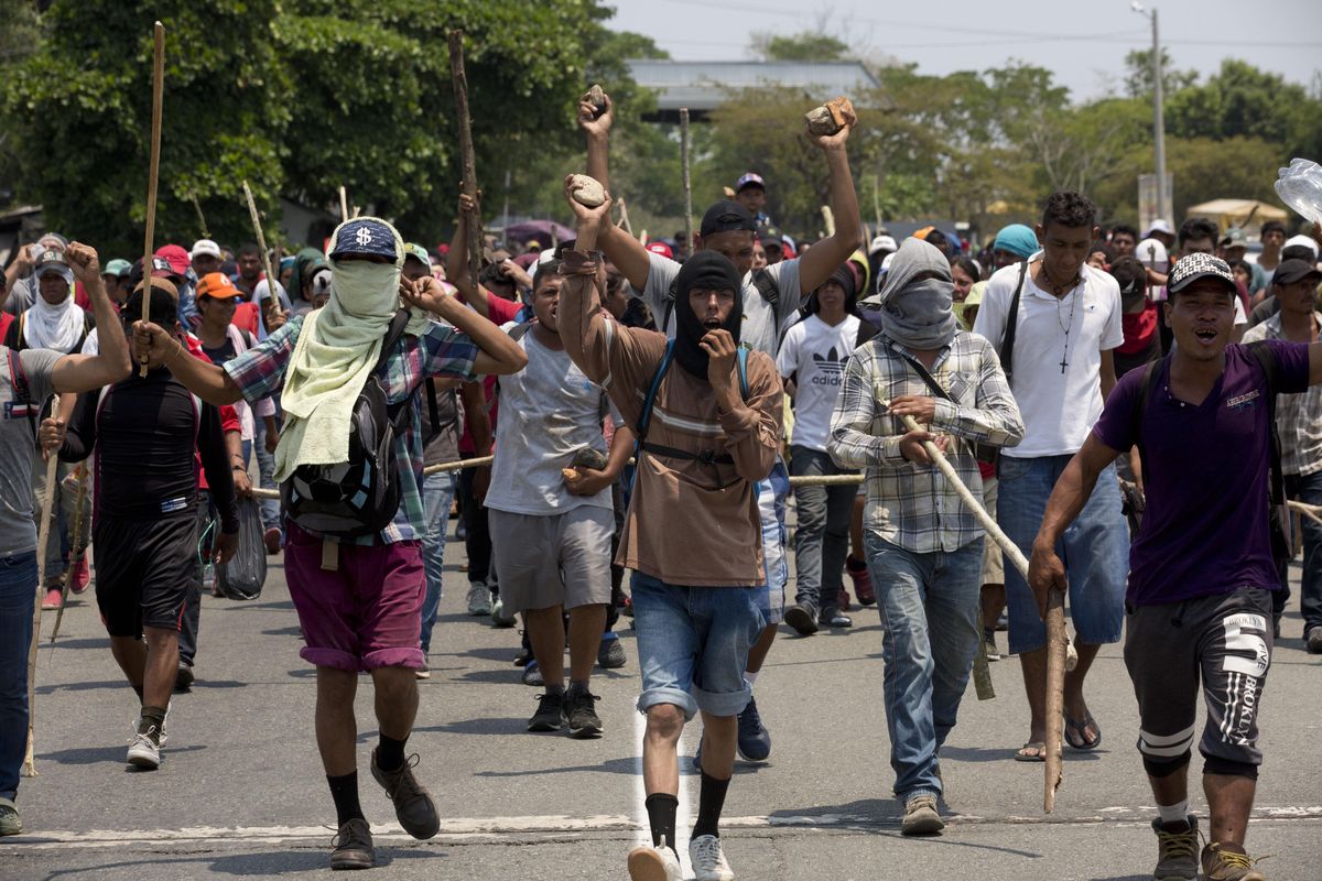After Mexican immigration agents detained some Central American migrants on the highway, other migrants from the group carry wooden sticks and stones for self-defense as they continue their trek to Pijijiapan, Mexico, Monday, April 22, 2019. Mexican police and immigration agents detained hundreds of migrants Monday in the largest single raid on a migrant caravan since the groups started moving through Mexico last year. (Moises Castillo / AP)