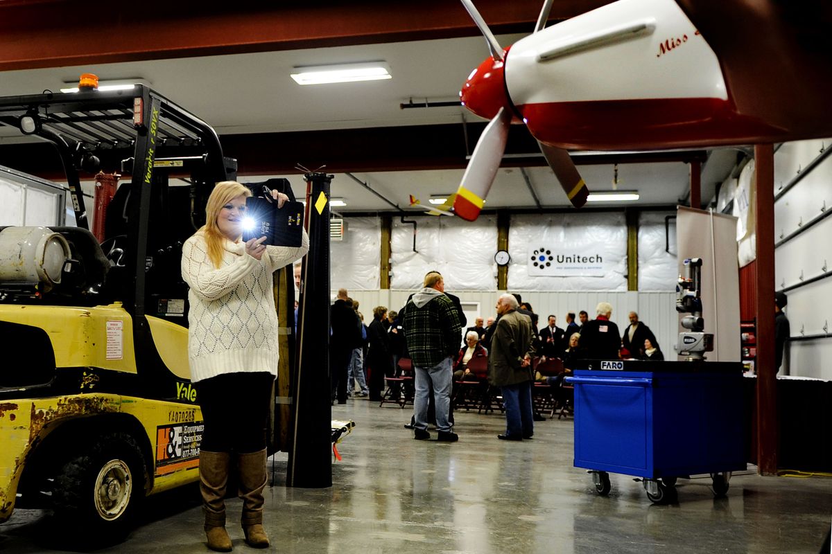 Alora Nick, of Newport, Wash., takes pictures of the displays before the opening of the North Idaho College Aerospace Center of Excellence in Coeur d’Alene on Thursday. (PHOTOS BY KATHY PLONKA)