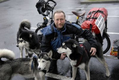 
Cancer survivor Randolph Westphal, shown with  his dogs Chinook, front left, Nanook, right, and Yukon  in the  Holiday Inn Express parking lot on East Mission in Spokane Valley on Wednesday,  is on his fourth  bicycling tour of  the world. 
 (Dan Pelle / The Spokesman-Review)